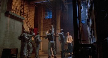 Movie still from “School Daze” (1988), directed by Spike Lee – A group of men standing in front of a brick building; Wide shot, Low angle