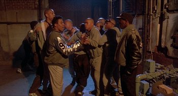 Movie still from “School Daze” (1988), directed by Spike Lee – A group of men standing next to each other on the street; Wide shot, High angle