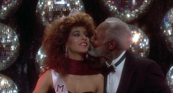 Movie still from “School Daze” (1988), directed by Spike Lee – An older man kissing a young woman on the cheek; Close Up shot, Low angle