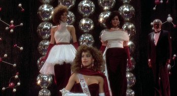 Movie still from “School Daze” (1988), directed by Spike Lee – A group of women in evening wear posing in front of disco balls; Medium shot, Low angle