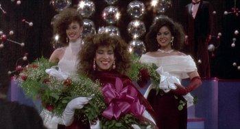 Movie still from “School Daze” (1988), directed by Spike Lee – A group of three women in formal attire holding flowers; Medium shot, Low angle