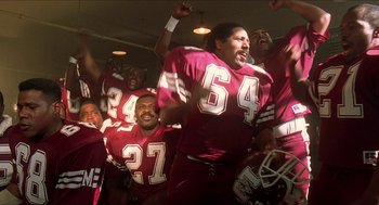 Movie still from “School Daze” (1988), directed by Spike Lee – A group of football players in a stadium; Medium shot, Low angle