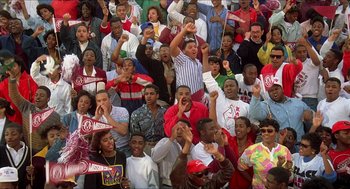 Movie still from “School Daze” (1988), directed by Spike Lee – A large group of young men and women in a stadium; Wide shot, High angle