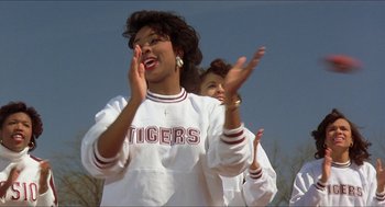 Movie still from “School Daze” (1988), directed by Spike Lee – A group of people standing next to each other clapping; Medium shot, Low angle