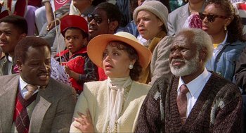 Movie still from “School Daze” (1988), directed by Spike Lee – A group of people sitting in a crowd watching something; Close Up shot, High angle