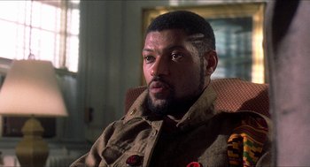 Movie still from “School Daze” (1988), directed by Spike Lee – A man with a beard and a military jacket; Close Up shot, Low angle