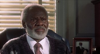 Movie still from “School Daze” (1988), directed by Spike Lee – An older man wearing a suit and a tie; Close Up shot, High angle