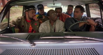 Movie still from “School Daze” (1988), directed by Spike Lee – A group of men sitting in the back of a car; Medium shot, Low angle