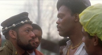 Movie still from “School Daze” (1988), directed by Spike Lee – A group of men standing next to each other on a field; Close Up shot, Over the shoulder angle