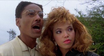 Movie still from “School Daze” (1988), directed by Spike Lee – A man and a woman standing next to each other; Close Up shot, Low angle