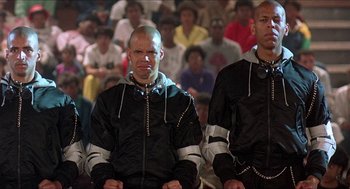 Movie still from “School Daze” (1988), directed by Spike Lee – A group of men sitting in front of an audience; Medium shot, Low angle