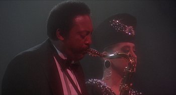 Movie still from “School Daze” (1988), directed by Spike Lee – A man and a woman playing a saxophone together; Close Up shot, Low angle