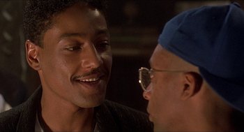 Movie still from “School Daze” (1988), directed by Spike Lee – Two men talking to each other in front of a mirror; Close Up shot, Over the shoulder angle