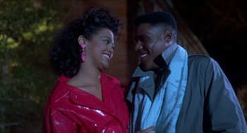 Movie still from “School Daze” (1988), directed by Spike Lee – A man and a woman smiling at each other; Close Up shot, Low angle