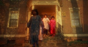 Movie still from “School Daze” (1988), directed by Spike Lee – A group of people standing on the steps of a building; Extreme Wide shot, Low angle