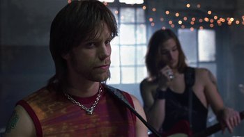 Movie still from “School of Rock” (2003), directed by Richard Linklater – A man with long hair wearing a necklace and a woman with long hair wearing a red shirt; Close Up shot, Low angle