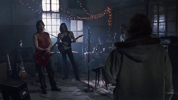 Movie still from “School of Rock” (2003), directed by Richard Linklater – A group of young people playing guitar in a room; Wide shot, Low angle