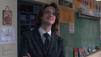 Movie still from “School of Rock” (2003), directed by Richard Linklater – A woman in a suit and tie smiling for the camera; Close Up shot, Low angle