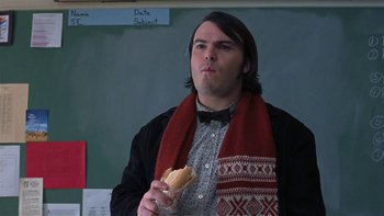 Movie still from “School of Rock” (2003), directed by Richard Linklater – A man with a scarf on holding a hot dog in his hand; Medium shot, Over the shoulder angle
