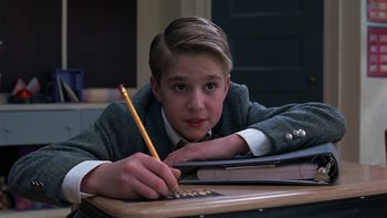Movie still from “School of Rock” (2003), directed by Richard Linklater – A young boy sitting at a desk writing on a piece of paper; Close Up shot, High angle