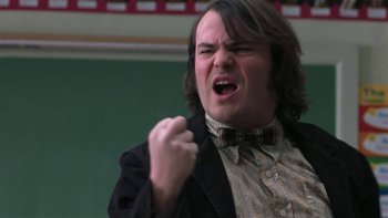 Movie still from “School of Rock” (2003), directed by Richard Linklater – A man with long brown hair wearing a bow tie; Close Up shot, Low angle