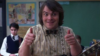 Movie still from “School of Rock” (2003), directed by Richard Linklater – A man giving two thumbs up while wearing a bow tie; Close Up shot, Low angle