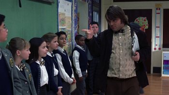 Movie still from “School of Rock” (2003), directed by Richard Linklater – A group of children standing in front of a man pointing; Medium shot, Over the shoulder angle