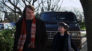 Movie still from “School of Rock” (2003), directed by Richard Linklater – A man standing next to a young girl in front of a truck; Medium shot, Over the shoulder angle