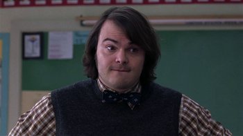 Movie still from “School of Rock” (2003), directed by Richard Linklater – A man with long hair wearing a vest and bow tie; Close Up shot, High angle