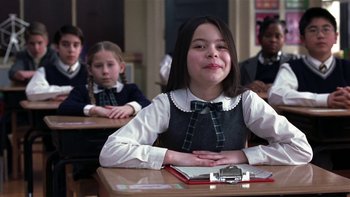 Movie still from “School of Rock” (2003), directed by Richard Linklater – A girl sitting at a desk in front of other students; Medium shot, Over the shoulder angle