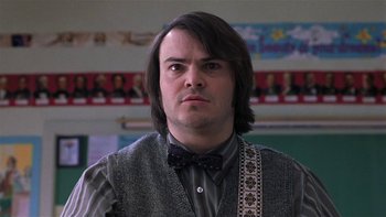Movie still from “School of Rock” (2003), directed by Richard Linklater – A man with long brown hair wearing a bow tie; Close Up shot, Low angle