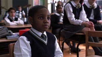 Movie still from “School of Rock” (2003), directed by Richard Linklater – A boy in a school uniform sitting in front of a class; Close Up shot, Low angle