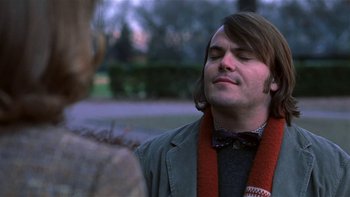 Movie still from “School of Rock” (2003), directed by Richard Linklater – A man with long brown hair wearing a bow tie; Close Up shot, Over the shoulder angle