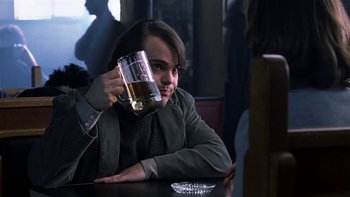 Movie still from “School of Rock” (2003), directed by Richard Linklater – A man sitting at a table holding a glass of beer; Close Up shot, Over the shoulder angle