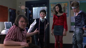 Movie still from “School of Rock” (2003), directed by Richard Linklater – A group of people standing in a living room; Medium shot, Over the shoulder angle