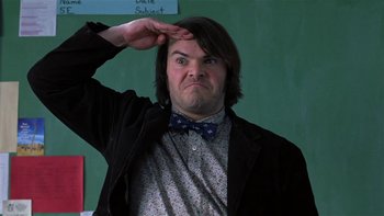Movie still from “School of Rock” (2003), directed by Richard Linklater – A man in a bow tie saluting in front of a chalkboard; Medium shot, Low angle