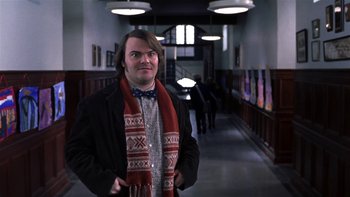 Movie still from “School of Rock” (2003), directed by Richard Linklater – A man in a black jacket and a red scarf; Medium shot, Low angle