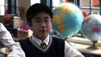 Movie still from “School of Rock” (2003), directed by Richard Linklater – A young man in a sweater and a tie; Close Up shot, High angle