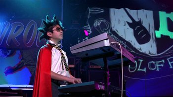 Movie still from “School of Rock” (2003), directed by Richard Linklater – A man in a costume playing a keyboard; Medium shot, Low angle