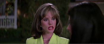 Movie still from “Scream 3” (2000), directed by Wes Craven – A person wearing a suit and a necklace; Close Up shot, Over the shoulder angle