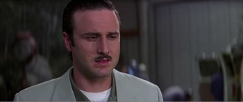 Movie still from “Scream 3” (2000), directed by Wes Craven – A person with a mustache wearing a suit; Close Up shot, Low angle