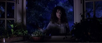 Movie still from “Scream 3” (2000), directed by Wes Craven – A woman standing in front of a bowl of flowers; Medium shot, Low angle