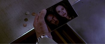 Movie still from “Scream 3” (2000), directed by Wes Craven – A woman holding a picture of a man and a woman; Extreme Close Up shot, High angle