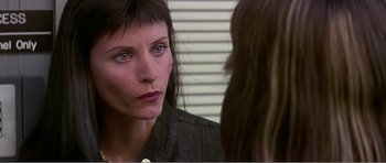 Movie still from “Scream 3” (2000), directed by Wes Craven – A woman looking into a mirror while standing next to another woman; Close Up shot, Over the shoulder angle
