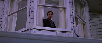Movie still from “Scream 3” (2000), directed by Wes Craven – A man looking out of a window at the camera; Medium shot, Low angle