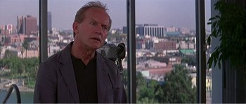 Movie still from “Scream 3” (2000), directed by Wes Craven – An older man standing in front of a large window; Close Up shot, Over the shoulder angle