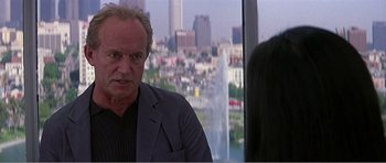 Movie still from “Scream 3” (2000), directed by Wes Craven – A man standing in front of a window with a city in the background; Close Up shot, Over the shoulder angle