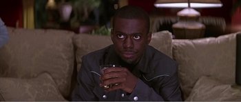 Movie still from “Scream 3” (2000), directed by Wes Craven – A man sitting on a couch holding a glass of wine; Close Up shot, Over the shoulder angle