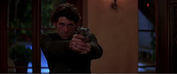 Movie still from “Scream 3” (2000), directed by Wes Craven – A man holding a gun in his hand; Close Up shot, Low angle