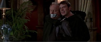 Movie still from “Scream 3” (2000), directed by Wes Craven – A man with duct tape around his mouth and another man with duct tape over his mouth; Close Up shot, Low angle